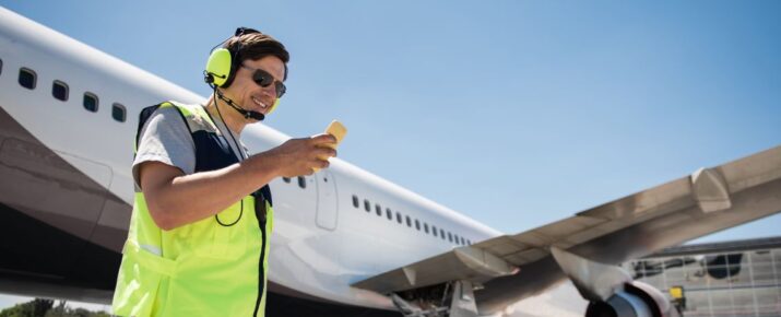 Airport ground crew looking at mobile phone